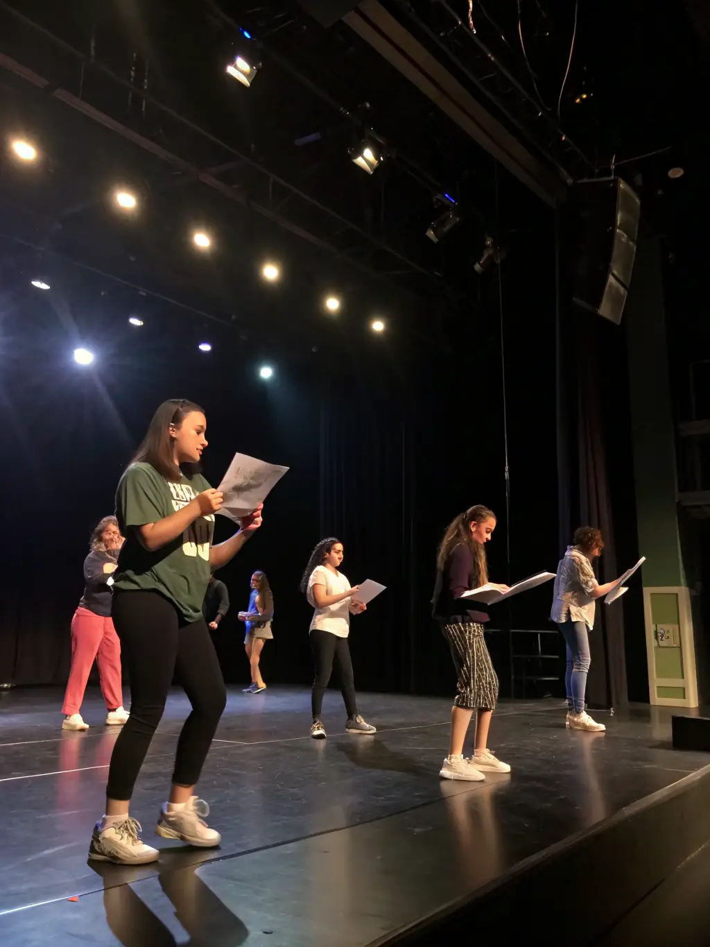 A photo of a theater instructor guiding students during a rehearsal, emphasizing the personalized attention and expert guidance provided by La Pirouette Théâtre.
